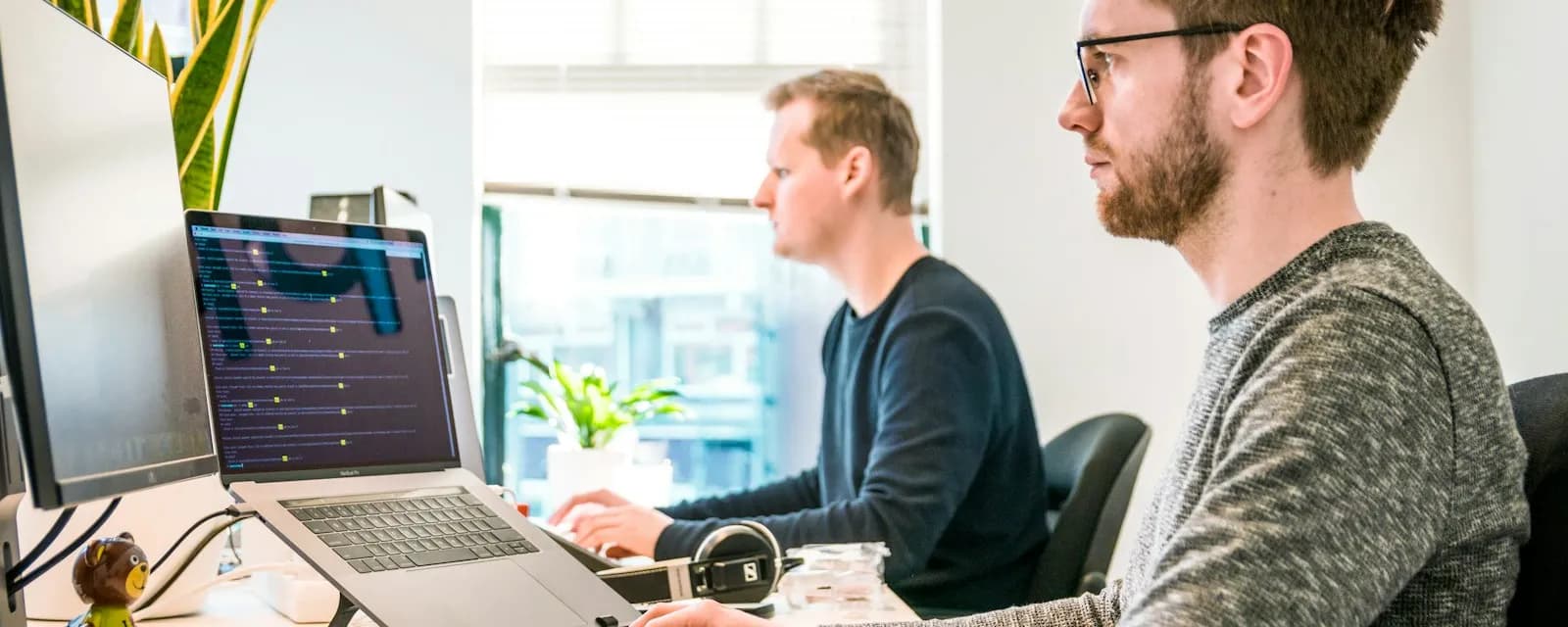 Dos analistas trabajando con sus ordenadores en una oficina