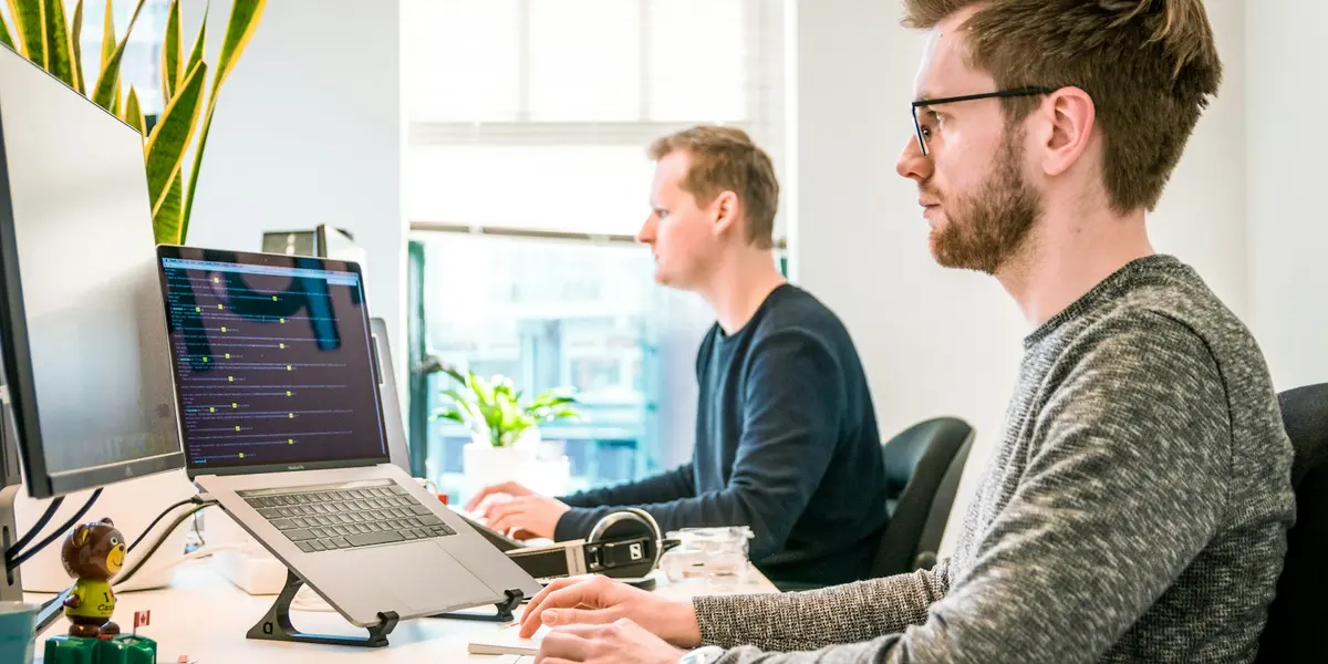Two analysts working at their computers in an office