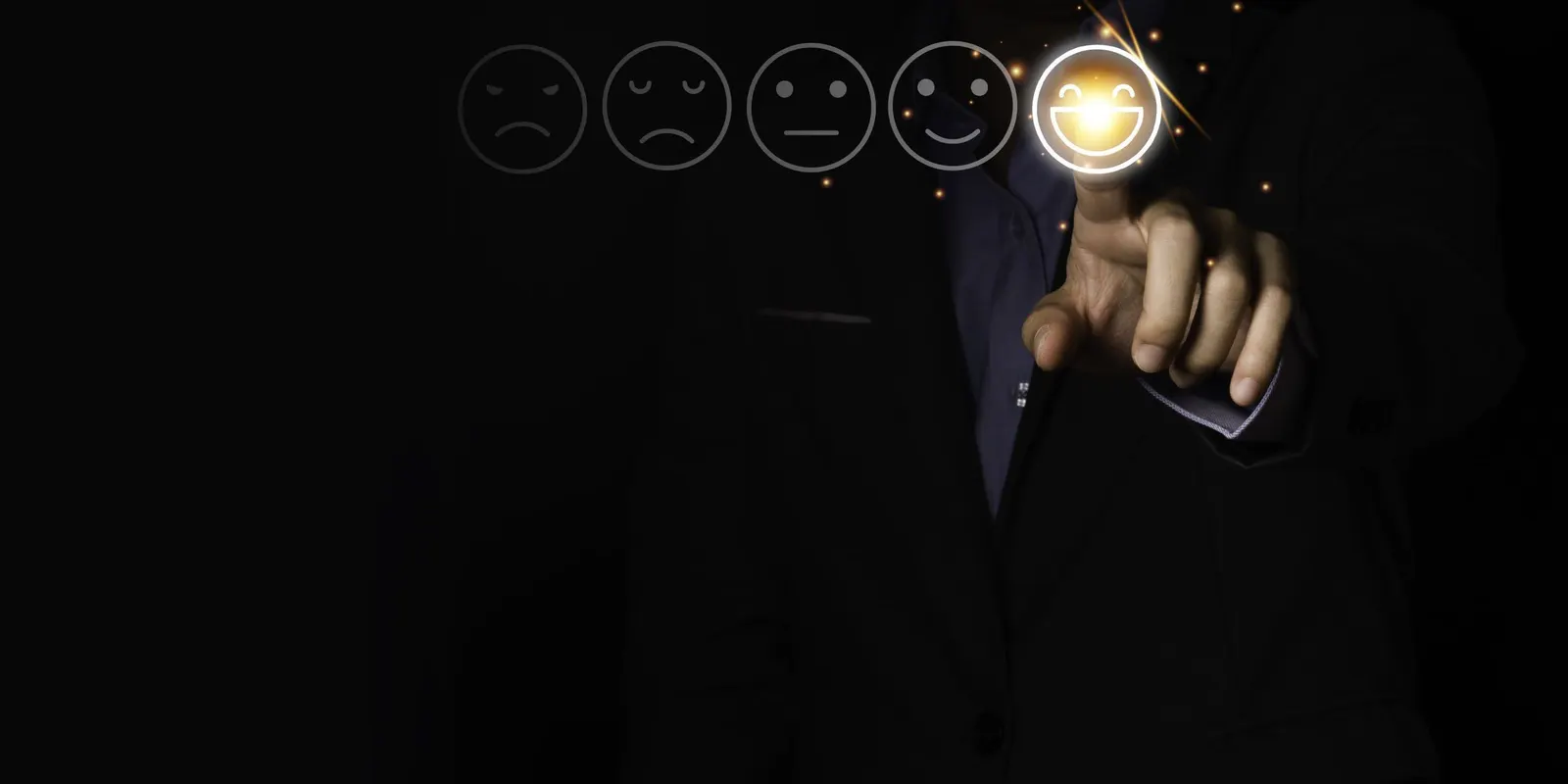 Una persona señala con el dedo la carita más sonriente de una escala de valoración de satisfacción